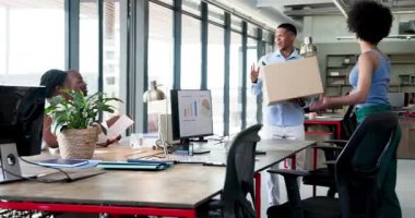 Çeşitli iş arkadaşları modern ofiste kutu, masa lambası, monitör ve su ile yeni bir işe başlıyorlar. Ofis, işbirliği, sohbet, takım çalışması, profesyonel, modern, katılım