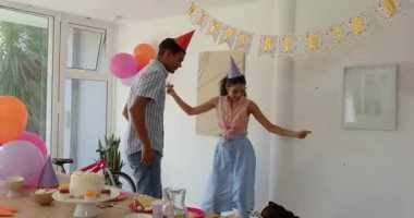 Aile doğum gününü evde pasta, tabak, bardak, balon ve afişle kutluyor. Kutlama, şenlik, toplanma, neşe, birliktelik, dekorasyon, etkinlik, aile dostu