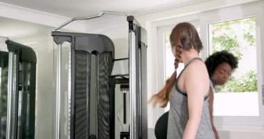 Modern spor salonunda çeşitli arkadaşlar ağırlık kaldırıyor, mor dambılları kavrıyor ve sıkı çalışıyor. Fitness, kuvvet, kararlılık, idman, güçlendirme, yoldaşlık, spor salonu