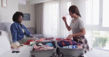 Afro-Amerikalı ve Asyalı arkadaşlar otel odalarını topluyor, kırmızı şapka kaldırıyor ve bavullarla ilgileniyorlar. Seyahat, macera, arkadaşlık, paketleme, tatil, otel, aksesuarlar, keyif