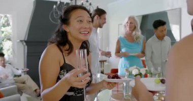 Çeşitli arkadaşlar köpüklü şarap şişesi patlatıyor, oturma odasına flüt döküyor ve tatlı tatlılar tadıyor. Kutlama, sosyalleşme, zarafet, yaşam tarzı, lüks, konukseverlik, sıcaklık