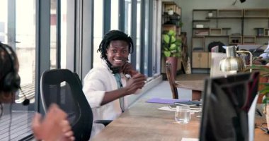 Afrikalı Amerikalı meslektaşlar modern ofiste bilgisayar ve su bardağıyla akranlarını tebrik ediyorlar. Kutlama, takım çalışması, başarı, işbirliği, pozitiflik, ofis, çalışma alanı