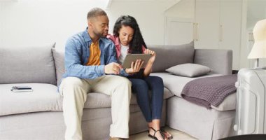 Oturma odasına giriyorlar, çeşitli çiftler tablet planlama gezisi yapıyor ve kart detaylarını giriyorlar. Yakınlık, teknoloji, rahatlama, ev, alışveriş, iletişim, konfor