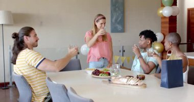 Partide, evde, arkadaşlar içkileri ve abur cuburları paylaşıyor, gülüyor ve sohbet ediyorlar. Arkadaşlık, sosyalleşme, toplanma, parti, rahatlama, rahatlama.