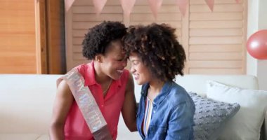 Kadınlar evde doğum günü kutluyor, gülümsüyor ve balonlarla el ele tutuşuyorlar. Kutlama, parti, arkadaşlık, mutluluk, neşe, şenlik