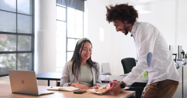 Orta Doğulu mutlu işadamı, ofisteki Çinli iş kadınına mum ve kek veriyor. Ofis partisi, eğlence, kutlama, iş, ofis ve iş ortamı kavramı.