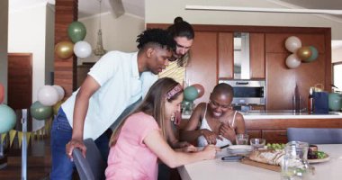 Partide, çeşitli arkadaşlar evdeki yemek masasının etrafında gülüp eğleniyorlar. Arkadaşlık, sosyalleşme, akşam yemeği, bağlanma, mutluluk, gündelik