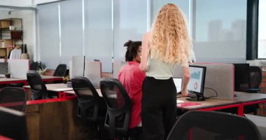 Çeşitli iş arkadaşları, modern açık-plan ofisindeki basılı belgeleri monitörlerle gözden geçiriyorlar. Takım çalışması, analiz, beyin fırtınası, üretkenlik, profesyonellik, yenilik, ergonomik