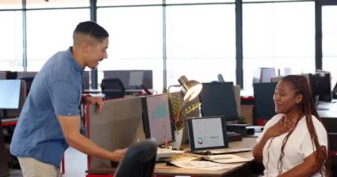 Afrika kökenli Amerikalı bir kadın ofiste genç bir adamla sohbet ediyor, doğum gününü dekorla kutluyor. Kutlama, takım çalışması, pozitiflik, modern, ofis, etkileşim, dekorasyon