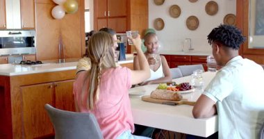 Partide, ayakta durup arkadaşlarla konuşurken, yemek masasında elinde aperatiflerle Afro-Amerikalı bir kadın. Sosyalleşme, toplama, çeşitlilik, sohbet, boş zaman, yoldaşlık