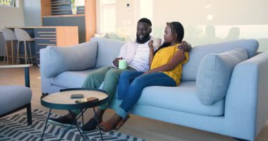 Kanepeye kurulurlar, Afro-Amerikan çiftler bardaklarını tokuştururlar, kahvelerini yudumlarlar, ekranın dışını gösterirler. Çift, rahatlama, samimiyet, ev, yaşam tarzı, gündelik, sıcaklık