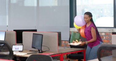 Afrika kökenli Amerikalı meslektaşlar hediye çantaları ve dekorasyonlarla modern ofiste kutlama yapıyorlar. Kutlama, takım çalışması, ofis, başarı, motivasyon, modern, dekorasyon