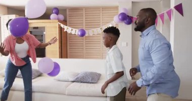 Doğum günü kutlaması, evde mor balonlarla oynayan neşeli bir çift. Kutlama, parti, mutluluk, eğlence, yaşam tarzı, canlı