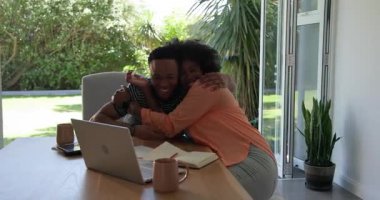 Genç çift evde dizüstü bilgisayar kullanırken ve kahve içerken planlarını tartışıyor. planlama, tartışma, oturma odası, ilişki