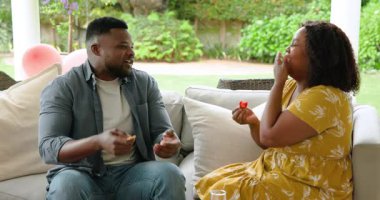 Kanepede oturan Afro-Amerikalı çift evde düşünceli bir konuşma yapıyorlar. ilişki, diyalog, iletişim, bağ