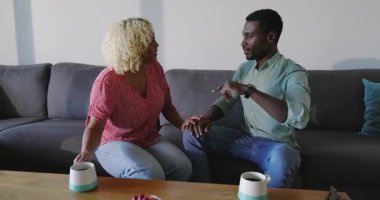 Kanepede oturup el ele tutuşan, ciddi ciddi konuşan bir çift. İlişki, iletişim, samimiyet, duygular, bağlanma