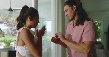 Evdeki havuza bakan sürgülü kapıların yanında konuşan bir çift, yüzük kutusuyla evlenme teklif eden bir adam. Romantizm, bağlılık, kutlama, yakınlık, zarafet, manzara, yerli