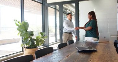 Afrika kökenli Amerikalı kadın çeşitli iş arkadaşlarıyla telefonda ve dizüstü bilgisayarla strateji tartışıyor. Çalışma alanı, işbirliği, iletişim, profesyonellik, yeşillik, katılım, modern