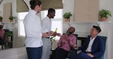 Farklı erkek arkadaşlar kelepçeleri ayarlar, kravat bağlarken üçüncü arkadaş eve bira ile yaklaşır. Tımar, yoldaşlık, yaşam tarzı, moda, kutlama, rahatlama, sosyalleşme