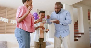 Aile, kutlama sırasında evde atıştırmalıkların ve kahkahaların keyfini çıkarıyor. Aile zamanı, birliktelik, tatil, mutluluk, kaynaşma, eğlence