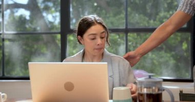 Modern ofiste dizüstü bilgisayar kullanan bir iş kadını, iş adamı ona pasta getiriyor. İş, iş, ofis ortamı kavramı.