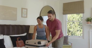 Romantik çift yatak odasına giriyor, bavulun fermuarını açıyor, günlük tutuyor, neşeyle sarılıyorlar. Romantizm, seyahat, samimiyet, ev, yaşam tarzı, kutlama, bağlantı