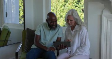 Çeşitli çiftler tablet tabletlere tıklıyor sonra da açık bavula gömlek koyuyorlar. Yaşlılar, arkadaşlık, organizasyon, yerli, yaşam tarzı, aile, farkındalık