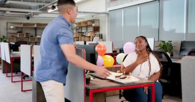 Çeşitli iş arkadaşları el çırpıyor. Doğum gününü çikolatalı pasta ve balonlarla kutluyorlar. Kutlama, takım çalışması, doğum günü, sevinç, ofis, tatlı, dekorasyon