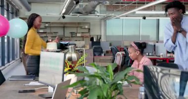 Dört meslektaş ofis üyelerini tebrik ediyor. Masalarında balonlar ve kartlarla toplanıyorlar. Kutlama, takım çalışması, işbirliği, motivasyon, modern, başarı, yoldaşlık