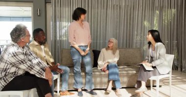 Klinikte, kadın terapist kadın hasta ve erkek hastalarla konuşuyor. Terapi, danışmanlık, akıl sağlığı, grup oturumu, iletişim, destek