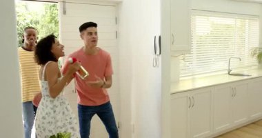 Çeşitli arkadaşlar, yeni evlerine yeni taşınan kadınlara taşınıp, yeni taşınma partilerini kutluyor. Mutfak, günlük, arkadaşlık, modern, güneş ışığı, aydınlık, rahat