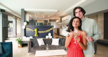 Şampanya içen ve oturma odasındaki yıldönümü partisinde kutlama yapan mutlu çift. Kutlama, yıldönümü, ilişki, parti ve yaşam tarzı konsepti.