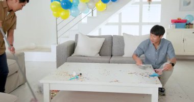 Asyalı baba ve oğul kutlama için balonlarla oturma odasını dekore ediyor. Partiye hazırlanıyorlar. Dekorasyon, festival, baba ve oğul, takım çalışması, hazırlık, etkinlik