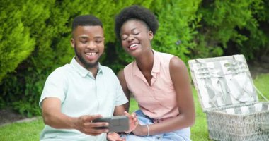 Genç bir çift bahçede selfie çekiyor, gülümsüyor ve birlikte dışarıda vakit geçiriyorlar. Mutluluk, yaşam tarzı, bağlanma, teknoloji