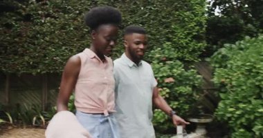 Genç çift yemyeşil bahçede eğleniyor, neşe içinde gülüyorlar. Mutluluk, açık hava, doğa, romantizm, bağ, aşk