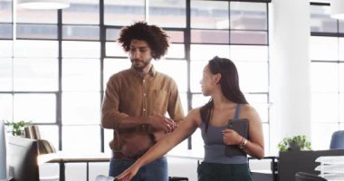 Mutlu Çinli iş kadını çeşitli erkek arkadaşlarıyla ofisi tanıtıyor, selamlıyor ve konuşuyor. Takım çalışması, iş ve iletişim konsepti.