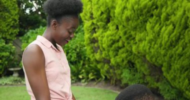 Genç adam parkta yüzükle evlenme teklif ediyor, kadın şaşırmış ve neşeli. Nişan, romantizm, aşk, çift, bağlılık, ilişki