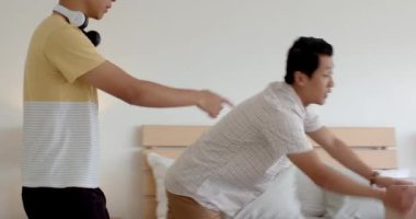 Asyalı baba ve oğul yatak odasında sımsıkı sarılıp sevgi ve bağlarını dile getiriyorlar. Aile, ebeveynlik, bağlılık, birliktelik, şefkat, samimiyet