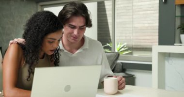Masada dizüstü bilgisayar kullanan ve oturma odasında kahve içen mutlu çift. İlişki, iletişim, yaşam tarzı ve aile hayatı kavramı.