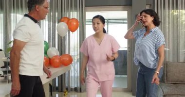 Mutlu hastalar ve bayan hemşire kliniğe yeni bir fizyoterapi hastası için ekipman hazırlıyorlar. Sağlık, tedavi ve fizyoterapi kavramı.