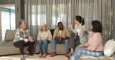 Klinikte, diğerleri izlerken terapist erkek hastaya sertifika veriyor. Ödül, terapi, başarı, kutlama, başarı, tanınma