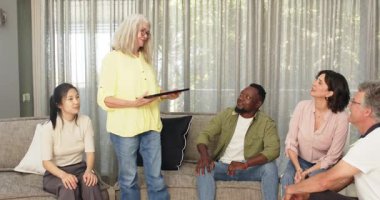 Mutlu kadın terapist hastalara heykel veriyor ve hastalarla grup terapisinde fotoğraf çekiyor. Takım çalışması, akıl sağlığı, iletişim ve terapi kavramı.