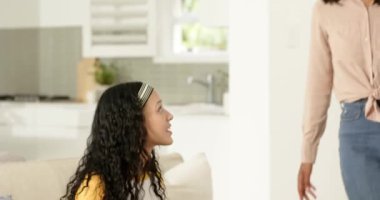 Anne elinde kupa, eve genç kız gibi bakıyor kart getiriyor ve kanepede sarılıyor. Aile, şefkat, bağ, konfor, ev, samimiyet, neşe