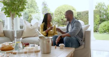 Olgun bir çift, sıcak oturma odası ortamında birlikte atıştırmalık ve içeceklerin tadını çıkarıyor. Yaşlılar, yoldaşlık, rahatlama, bağlanma, ev içi, yaşam tarzı