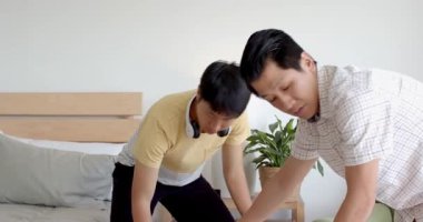 Asyalı adamlar ellerinde bant kutusuyla karton kutu paketliyor, proje üzerinde çalışıyorlar. Paketleme, takım çalışması, işbirliği, çeşitlilik, el işi, lojistik