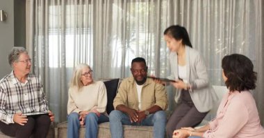 Klinikte, diğerleri izlerken terapist kadın hastaya sertifika veriyor. Mezuniyet, başarı, kutlama, tanınma, destek, terapi