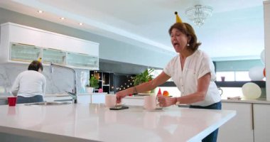 Mutfaktaki partiden sonra tezgahı ve dekorasyonu temizleyen kıdemli bayan arkadaşların kutlu olsun. Kutlama, doğum günü, parti, son sınıf yaşam tarzı ve arkadaşlık konsepti.