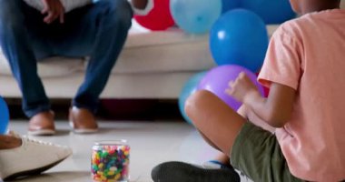 Mutlu siyah çift ve onların çok ırklı oğulları balo düzenliyor ve gülümsüyor, çocuğun doğum gününü evde kutluyorlar. Doğum günü, kutlama, parti, aile, çocukluk, ev hayatı ve ilişki kavramı.