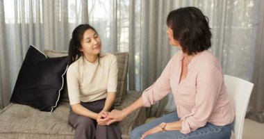 Mutlu kadın terapist ve hasta el ele tutuşup grup terapisinde konuşuyor. Takım çalışması, akıl sağlığı, iletişim ve terapi kavramı.