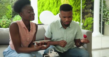 Genç çift taze meyve tabağının keyfini çıkarıyor ve rahat verandada hediyelerimizi değiş tokuş ediyoruz. Romantizm, açık hava, kutlama, rahatlama, yemek, yaşam tarzı